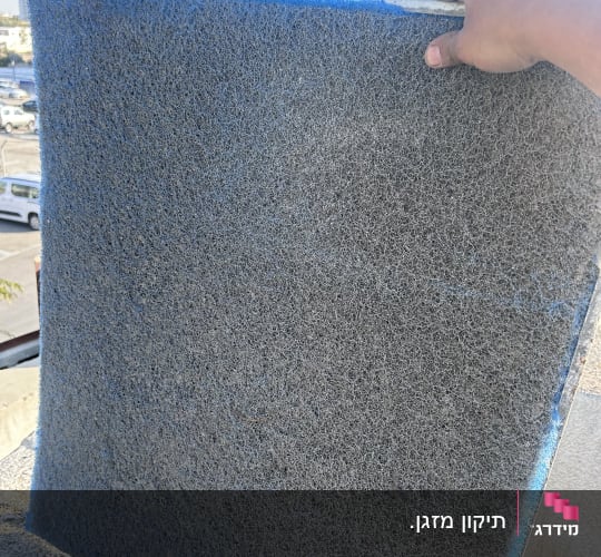פילטר אוויר מוחזק ביד על רקע שמיים